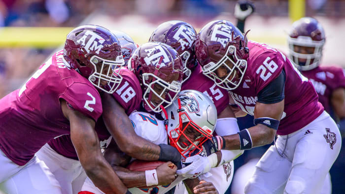 The Texas A&M defense swarms New Mexico quarterback Terry Wilson.